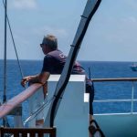 man looking out at ocean from boat