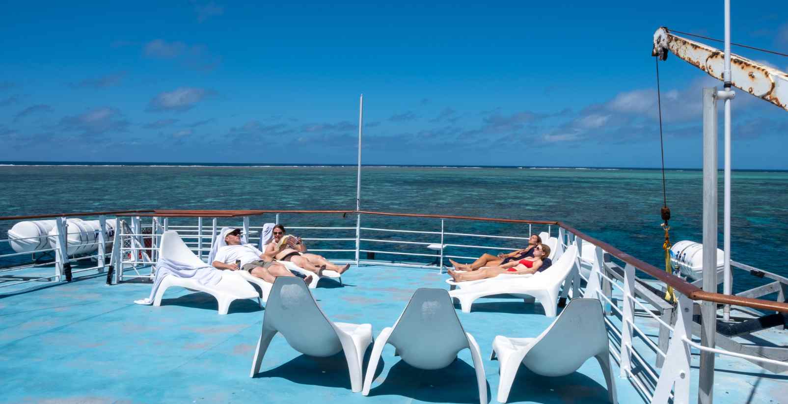 people relaxing on boat deck